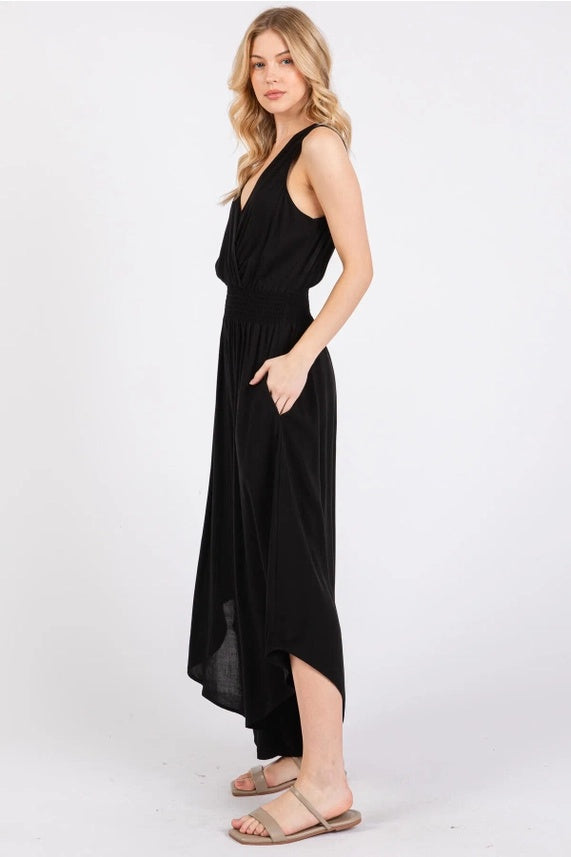 Woman wearing a black sleeveless Smock Waist Jumpsuit on a white background