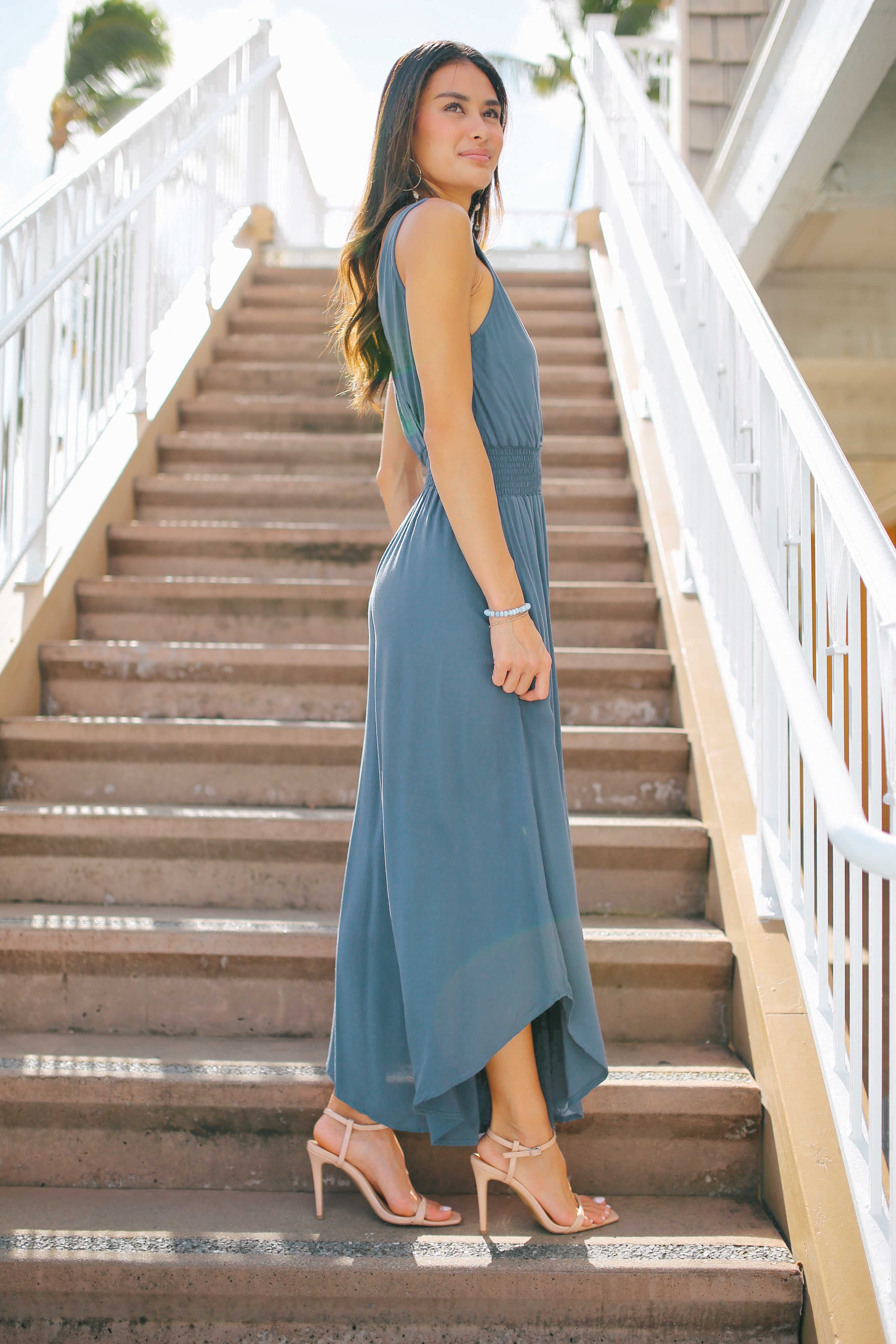 Woman in a blue Smock Waist Jumpsuit standing on outdoor steps
